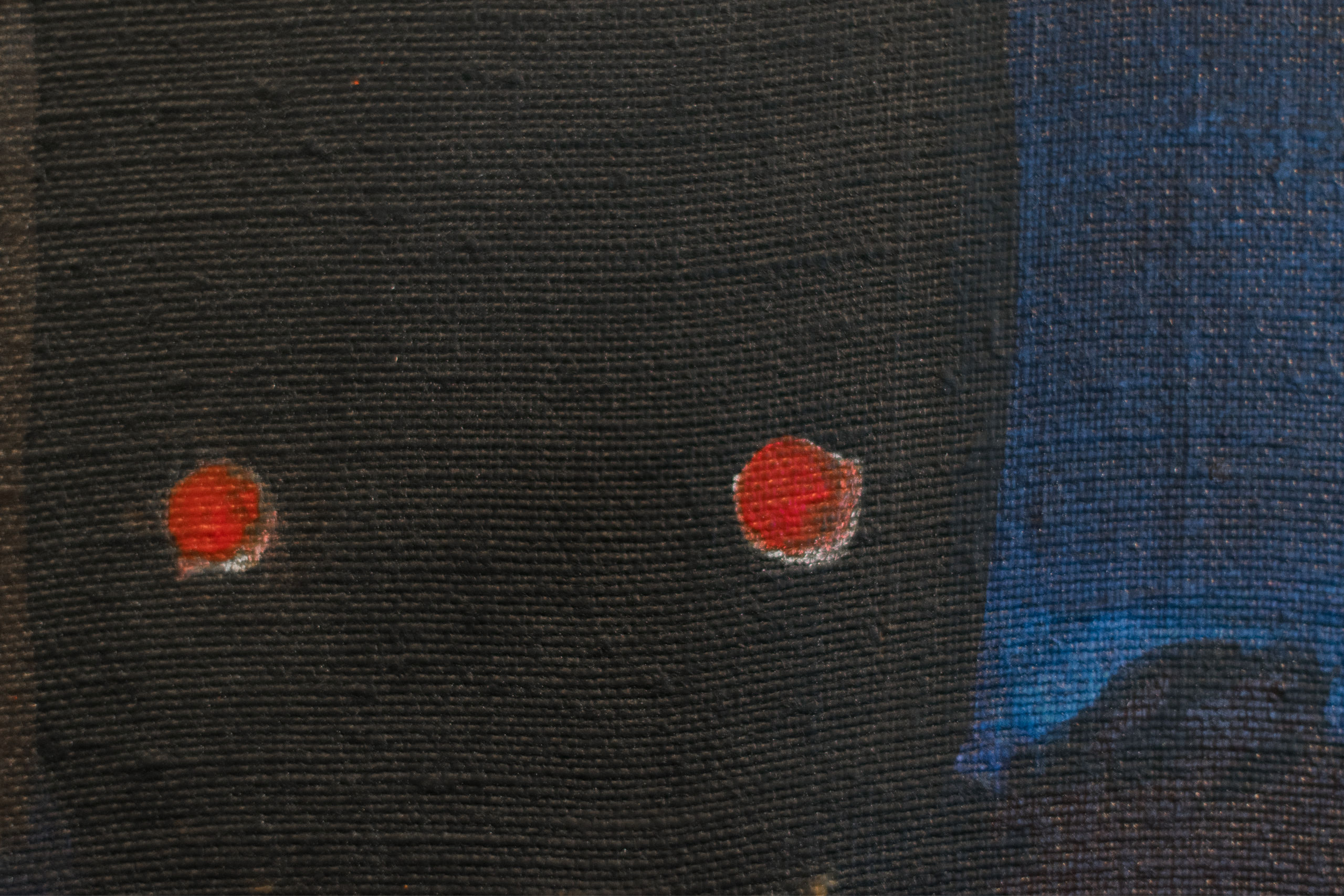Close-up of painting showing black, blue and red tones.